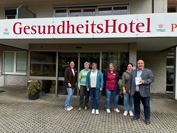 Das Team des Gesundheitshotels und Seniorenzentrums steht vor dem Eingang. Es hat soeben die Auszeichnung "einfach, barrierefrei" erhalten.