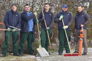 Gruppenbild mit fünf Männern. Sie halten Heckenschere, Schaufel und Besen in der Hand.