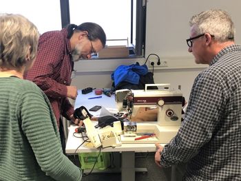 Zwei Bürger erhalten Unterstützung bei der Reparatur.