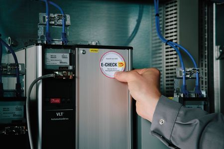 Ein E-Check-Aufkleber wird auf ein elektrisches Gerät aufgeklebt.