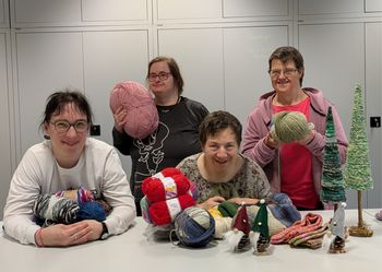 Mitarbeiter der Manufakturgruppe mit Wolle und Adventsartikeln