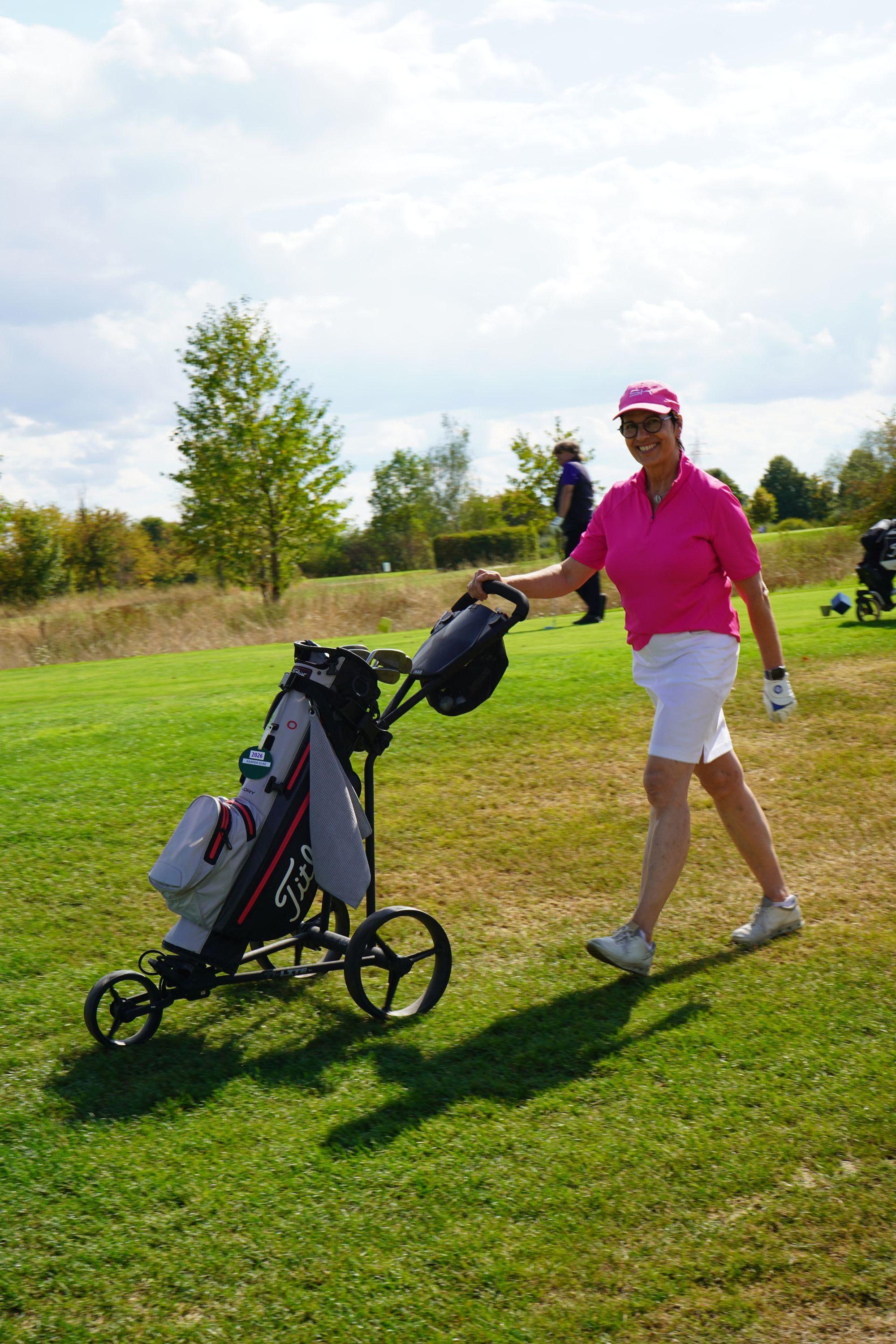 Eine Golfspielerin mit ihrem Golfbag