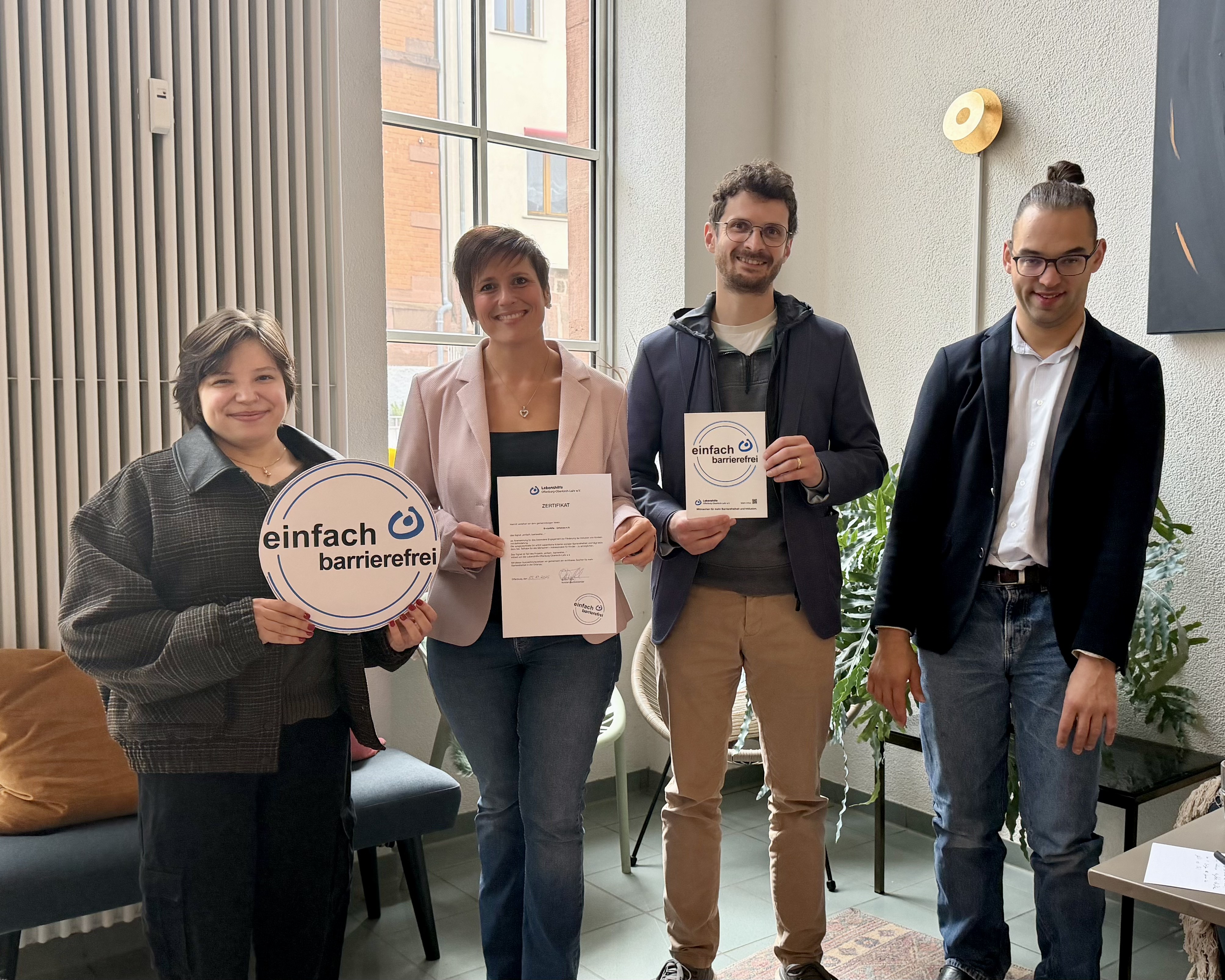 Polina Ullrich (links) und Thibau Bry (rechts) übergaben das Label "einfach, barrierefrei" an Marina Irslinger (Löwenherz Familiencoaching) und Konstantin Schneider (ErsteHilfe-Ortenau)